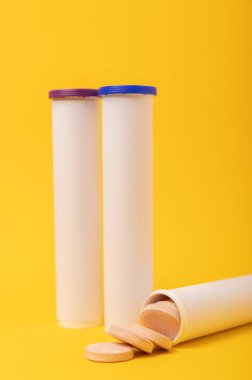 Multivitamin coşkulu haplar. Çözünür C vitamini tabletleri. Kalsiyum vitamini. Sarı arka planda şişirilmiş vitamin. Tıp konsepti. Dokunulmazlık. Metin için yer.