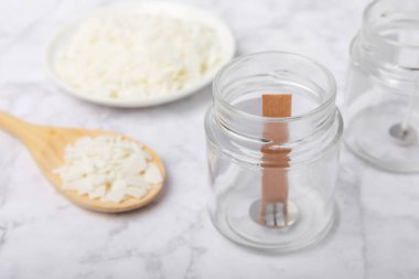 Ev yapımı beyaz çevre dostu mumlar, cam, fitil, beyaz mermer üzerine parfüm. Hobi, iş. Kendi ellerinle mum yapıyorsun. Vejetaryen ürünü. Boşluğu kopyala.