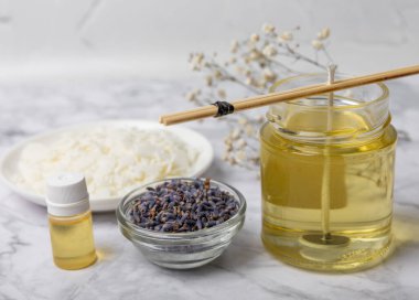 Ev yapımı beyaz çevre dostu mumlar, cam, fitil, beyaz mermer üzerine parfüm. Hobi, iş. Kendi ellerinle mum yapıyorsun. Vejetaryen ürünü. Boşluğu kopyala.