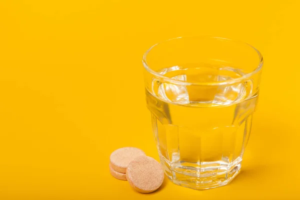 Comprimido Vitamina Efervescente Cai Dissolve Copo Água Fundo Amarelo Conceito — Fotografia de Stock