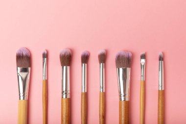 Pembe arka planda kozmetik makyaj fırçası. Makyaj için kozmetik ürün. Yaratıcı ve güzel moda konsepti. Moda. Kozmetik makyaj fırçası koleksiyonu, üst görüş, afiş. Mesaj için yer. MOCAP.