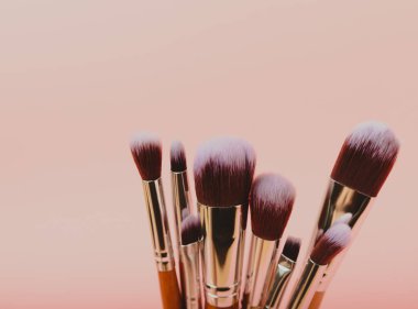 Pembe arka planda kozmetik makyaj fırçası. Makyaj için kozmetik ürün. Yaratıcı ve güzel moda konsepti. Moda. Kozmetik makyaj fırçası koleksiyonu, üst görüş, afiş. Mesaj için yer. MOCAP.