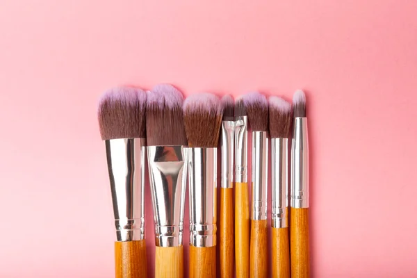 Cosmetic makeup brush on a pink background. Cosmetic product for make-up. Creative and beauty fashion concept. Fashion. Collection of cosmetic makeup brushes, top view, banner.Place for text. MOCAP.