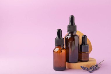 Pembe bir arka planda kokulu yağ ve lavanta çiçekli bir şişe. Aromaterapi. Rahatla. Spa tedavileri ve cilt bakımı konsepti. Güzellik prosedürü.