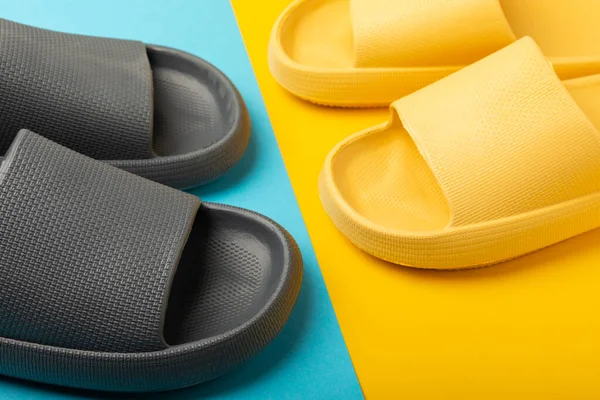 Bright rubber slippers on a yellow-blue background. Summer slates. Indoor shoes. Place for text. FLAT LAY