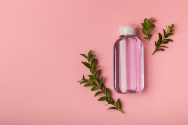 Micellar temizleme suyu, pembe arka planda tonik, üst görüş. Her gün hassas temizlik konsepti. Kozmetik ve sebiyumdan deri temizleme. Cilt bakımı kavramı.