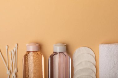 Micellar temizleme suyu, pamuk tomurcukları, bej arka planda havlu ve pamuk pedleri. En iyi görüntü. Hassas temizlik günlük konsepti. Kozmetik ve sebiyumdan deri temizleme. Cilt bakımı kavramı.