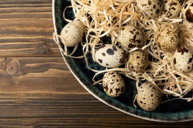 Koyu kahverengi ahşap arka planda bir tabakta bıldırcın yumurtası. Sağlıklı yiyecekler. Diyet olsun. Üst Manzara. boş alan.