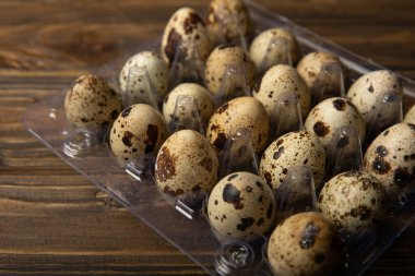 Koyu kahverengi ahşap arka planda plastik bir pakette bıldırcın yumurtası. Sağlıklı yiyecekler. Diyet olsun. Üst Manzara. boş alan.