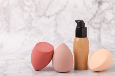 Mermer zemin üzerinde güzellik blenderi. Makyaj süngeri ve vakıf. Güzellik konsepti. Vakıf, pansiyon kremi ya da uyku kapağı için sünger. Mesaj için yer. Boşluğu kopyala.