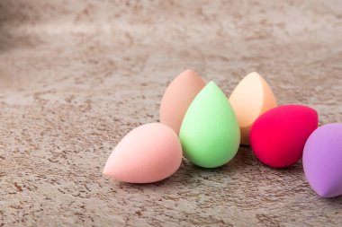 Kahverengi mermer arka planda güzellik blenderi. Makyaj süngeri. Güzellik konsepti. Vakıf, pansiyon kremi ya da uyku kapağı için sünger. Mesaj için yer. Boşluğu kopyala.