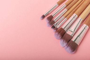 Pembe arka planda makyaj fırçaları. Şık bir arka plan. Kozmetik makyaj fırçası koleksiyonu. Çok güzel bir kavram. Makyaj aleti. Mesaj için yer. Kopyalanacak yer.