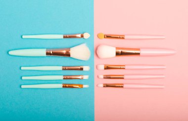 Pembe-mavi arka planda makyaj fırçaları. Şık bir arka plan. Kozmetik makyaj fırçası koleksiyonu. Çok güzel bir kavram. Makyaj aleti. Mesaj için yer. Kopyalanacak yer.