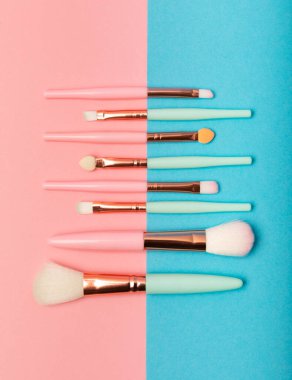 Pembe-mavi arka planda makyaj fırçaları. Şık bir arka plan. Kozmetik makyaj fırçası koleksiyonu. Çok güzel bir kavram. Makyaj aleti. Mesaj için yer. Kopyalanacak yer.