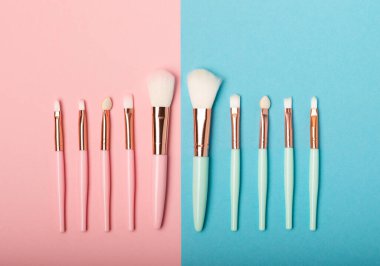 Pembe-mavi arka planda makyaj fırçaları. Şık bir arka plan. Kozmetik makyaj fırçası koleksiyonu. Çok güzel bir kavram. Makyaj aleti. Mesaj için yer. Kopyalanacak yer.