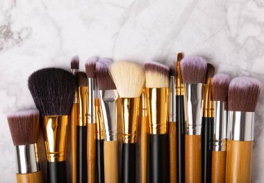 Beyaz mermer arka planda makyaj fırçaları. Kozmetik makyaj fırçası koleksiyonu. Çok güzel bir kavram. Makyaj aleti. Mesaj için yer. Kopyalanacak yer.