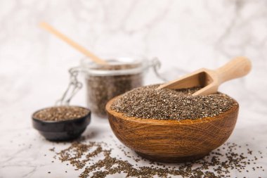 Ahşap bir kasede Chia tohumları ve beyaz mermer bir arka planda tahta bir kaşık. Süper yemek. Antioksidan. Sağlıklı yiyecekler. Diyet.