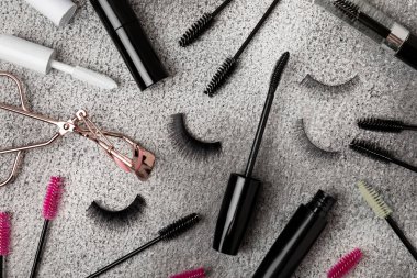 Takma kirpikli bileşim, rimel ve kirpik fırçaları, siyah desenli arka planda kirpik bigudileri. Makyaj aletleri. Güzellik konsepti. Makyaj. Mesaj için yer. Kopyalama yeri. Düz çizgi. MOCAP.