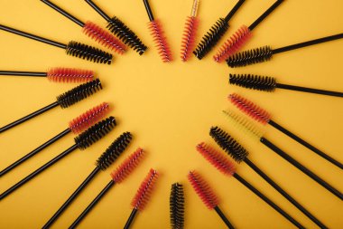 Sarı arka planda kirpik uzantısı için fırçalar. Kirpikleri taramak için fırça. Kirpikleri ve kaşları düzeltmek için fırça..