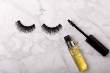 Kirpiklerin büyümesi için jel. Serum, beyaz mermer zemin üzerinde güçlü bir etkisi olan kirpik büyümesi için gerekli yağlar veya esanslar. Mesaj için yer. Kopyalanacak yer. MOCAP