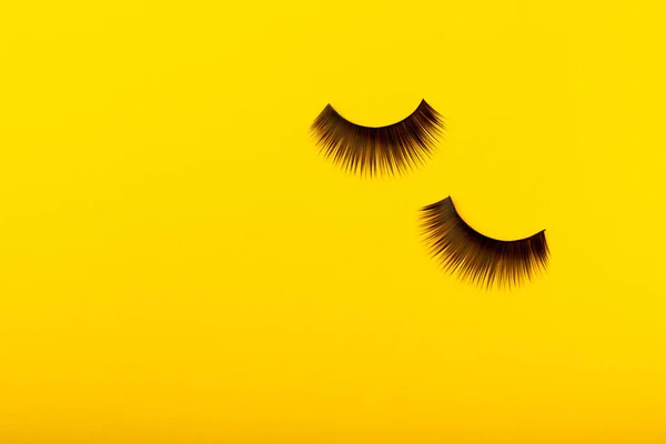 False eyelashes on a yellow background. Flatley. Beauty and fashion concept. Eyelash extension. beauty industry. Place for text. Place to copy.