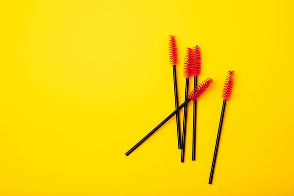 Brushes for eyelash extension on a yellow background. Brush for combing eyelashes.brush for straightening eyelashes and eyebrows.