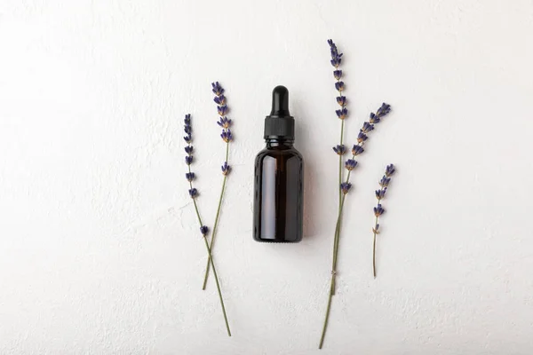 Lavender essential oil with lavender flowers on white texture background. Aromatherapy and spa concept. Beauty. Relax.