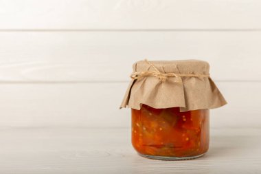 Camdan bir kavanozda dokulu bir masada Lecho salatası. Cam kavanozlarda sebze salatası. Ev yapımı konserve yiyecekler. Ürünlerin korunması ve depolanması. Mesaj için yer. Boşluğu kopyala.