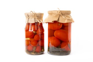 Beyaz arka planda izole edilmiş cam bir kavanozda kırmızı domates turşusu. Sonbahar ya da kış için gıda korunumu. Ev deposu. Konserve, fermantasyon konsepti. Mesaj için yer. Boşluğu kopyala.