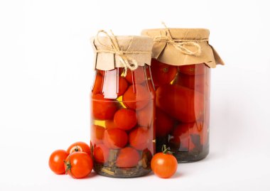 Beyaz arka planda izole edilmiş cam bir kavanozda kırmızı domates turşusu. Sonbahar ya da kış için gıda korunumu. Ev deposu. Konserve, fermantasyon konsepti. Mesaj için yer. Boşluğu kopyala.