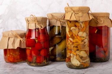 Açık dokuya sahip kavanozlar dolusu sebze, salatalık, domates, mantar ve patlıcan. Turşu ve konserve yiyecekler. Uzayı kopyala Metin için yer.