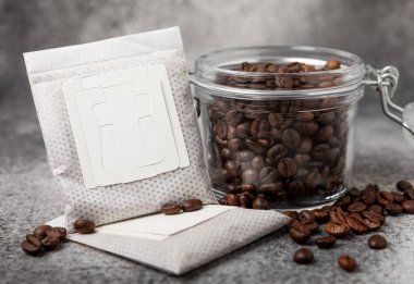 Kahve poşeti ve kahve çekirdekleri, siyah mermer bir fincanda demlenmek için öğütülmüş kahve. Damlayan kahve için filtre. Düz çizgi. Uzayı kopyala Metin için yer.