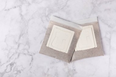 Kahve torbasını dokulu bir masada demlenmek için öğütülmüş kahveyle damlat. Kahve filtresi. Düz çizgi. Uzayı kopyala Metin için yer.