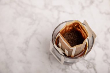 Bir fincan taze kahve ya da fincanda kahve kesesi filtresi. Özel bir tadı olan damlatılmış kahve yapmak. Kahve poşetini kahve bardağına dök. Evde kahve demleme modası. Mesaj için yer var. Boşluğu kopyala.