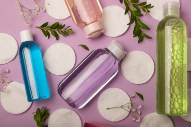 Mor arka planda Micellar su ve pamuk pedleri. Makyaj ve sebum silme toneri. Tonik, serum ya da losyon. Cilt bakımı. Güzellik konsepti. FLETLEY. Süper manzara. Mesaj için yer. Boşluğu kopyala