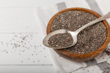 Kaşıkta Chia tohumları ve beyaz dokuda bir masa. Süper yiyecek ve aksiyoner. Diyet olsun. Yakın plan. Mesaj için yer. Boşluğu kopyala.