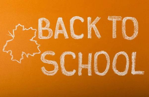 Chalk lettering back to school on a brown textural background. Concept of learning.