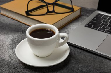 Laptop, kahve fincanı, gözlük, not defteri ve kalem, ofis konsepti. İş konsepti. Evde çalış. Bilgisayarlı çalışma alanı. Mocap. Mesaj için yer. Boşluğu kopyala.