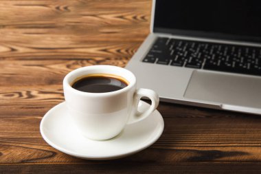 Laptop ve kahve fincanı ofis. Ofis konsepti. İş konsepti. Evde çalış. Bilgisayarlı çalışma alanı. Mocap. Mesaj için yer. Boşluğu kopyala.