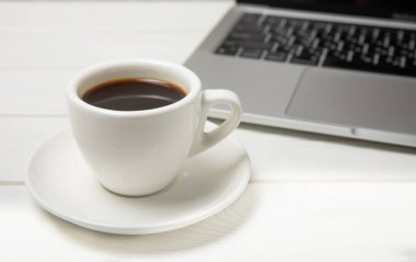 Laptop ve kahve fincanı ofis. Ofis konsepti. İş konsepti. Evde çalış. Bilgisayarlı çalışma alanı. Mocap. Mesaj için yer. Boşluğu kopyala.