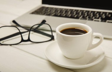 Laptop ve kahve fincanı ofis. Ofis konsepti. İş konsepti. Evde çalış. Bilgisayarlı çalışma alanı. Mocap. Mesaj için yer. Boşluğu kopyala.