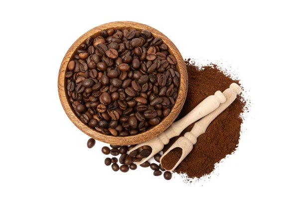 Ground coffee and coffee beans in wooden bowl and spoons isolated on white background.