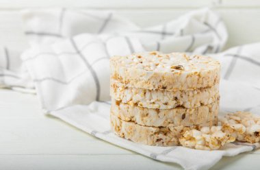 Beyaz desenli ahşap üzerinde çıtır çıtır pirinç kekleri. Diyet ekmek. Diyet olsun. Düzgün beslenme. GLUTEN ÖZGÜR. Uzayı kopyala Metin için yer.