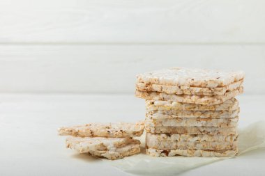 Beyaz desenli ahşap üzerinde çıtır çıtır pirinç kekleri. Diyet ekmek. Diyet olsun. Düzgün beslenme. GLUTEN ÖZGÜR. Uzayı kopyala Metin için yer.