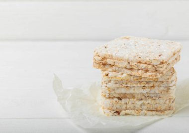 Beyaz desenli ahşap üzerinde çıtır çıtır pirinç kekleri. Diyet ekmek. Diyet olsun. Düzgün beslenme. GLUTEN ÖZGÜR. Uzayı kopyala Metin için yer.