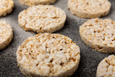 Siyah desenli arka planda bir yığın çıtır pirinç keki. Diyet ekmek. Diyet olsun. Düzgün beslenme. GLUTEN ÖZGÜR. Uzayı kopyala Metin için yer.
