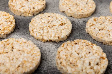 Siyah desenli arka planda bir yığın çıtır pirinç keki. Diyet ekmek. Diyet olsun. Düzgün beslenme. GLUTEN ÖZGÜR. Uzayı kopyala Metin için yer.