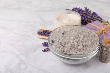 Spa lavantası. Beyaz mermer arka planda deniz tuzu, vücut kremi ve el yapımı sabun. Lavanta çiçekli doğal kozmetik ürünleri. Relak ve rahatlama. Aromaterapi. güzellik konsepti