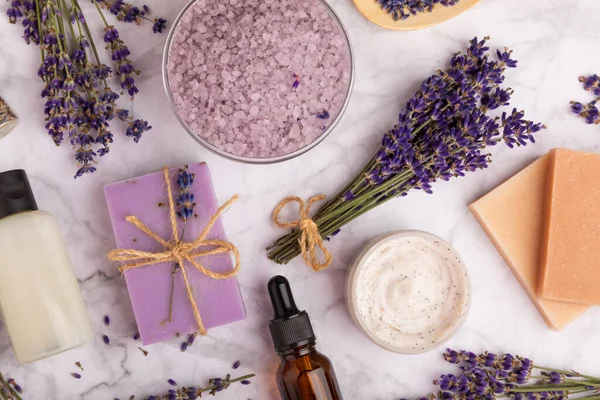 spa lavender. Sea salt, body cream, essential oil and handmade soap on a white marble background. Natural cosmetics on herbs with lavender flowers. Relak and relaxation. Aromatherapy. beauty concept