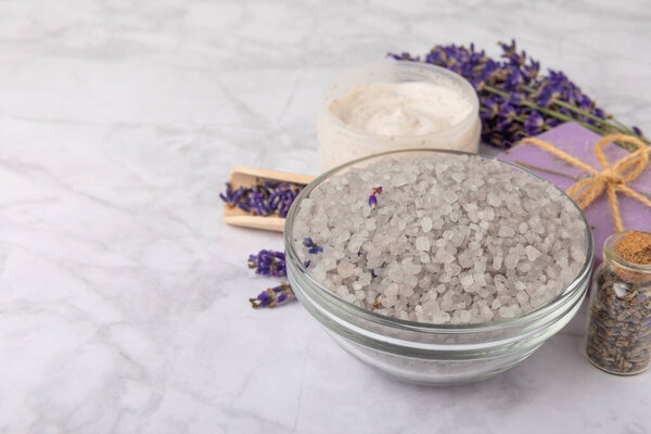 спа-лаванда. Морская соль, крем для тела и мыло ручной работы на белом мраморном фоне. Натуральная косметика на травах с лавандовыми цветами. Расслабьтесь и расслабьтесь. Ароматерапия. концепция красоты